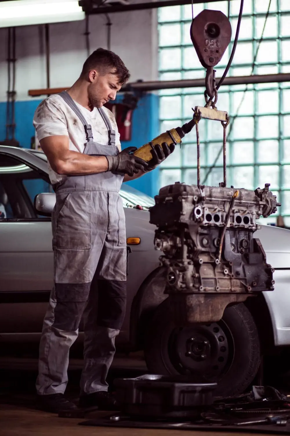 Mechanic inspecting a vehicle's engine before recovery transport