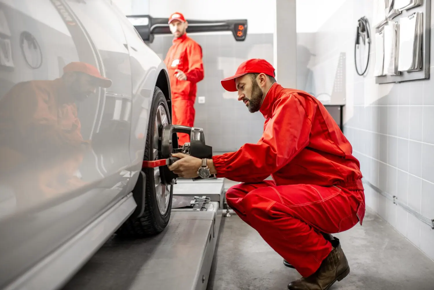 Technician checking wheel and tyre alignment after a tyre blowout