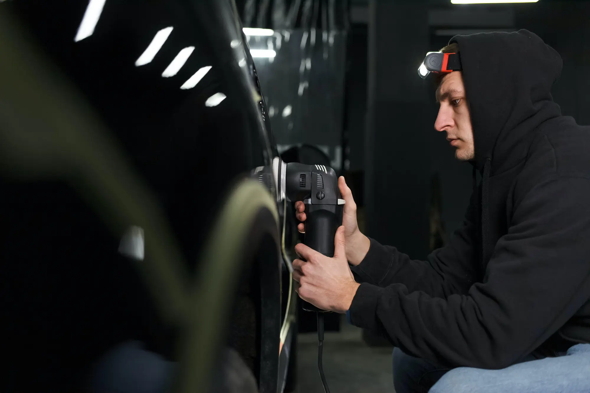 Detailer polishing the bodywork of a classic car before transport
