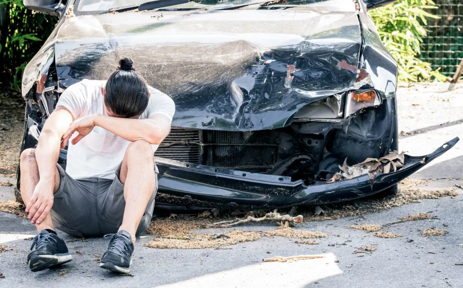 Driver stood next to damaged vehicle after a road accident in Stoke-on-Trent