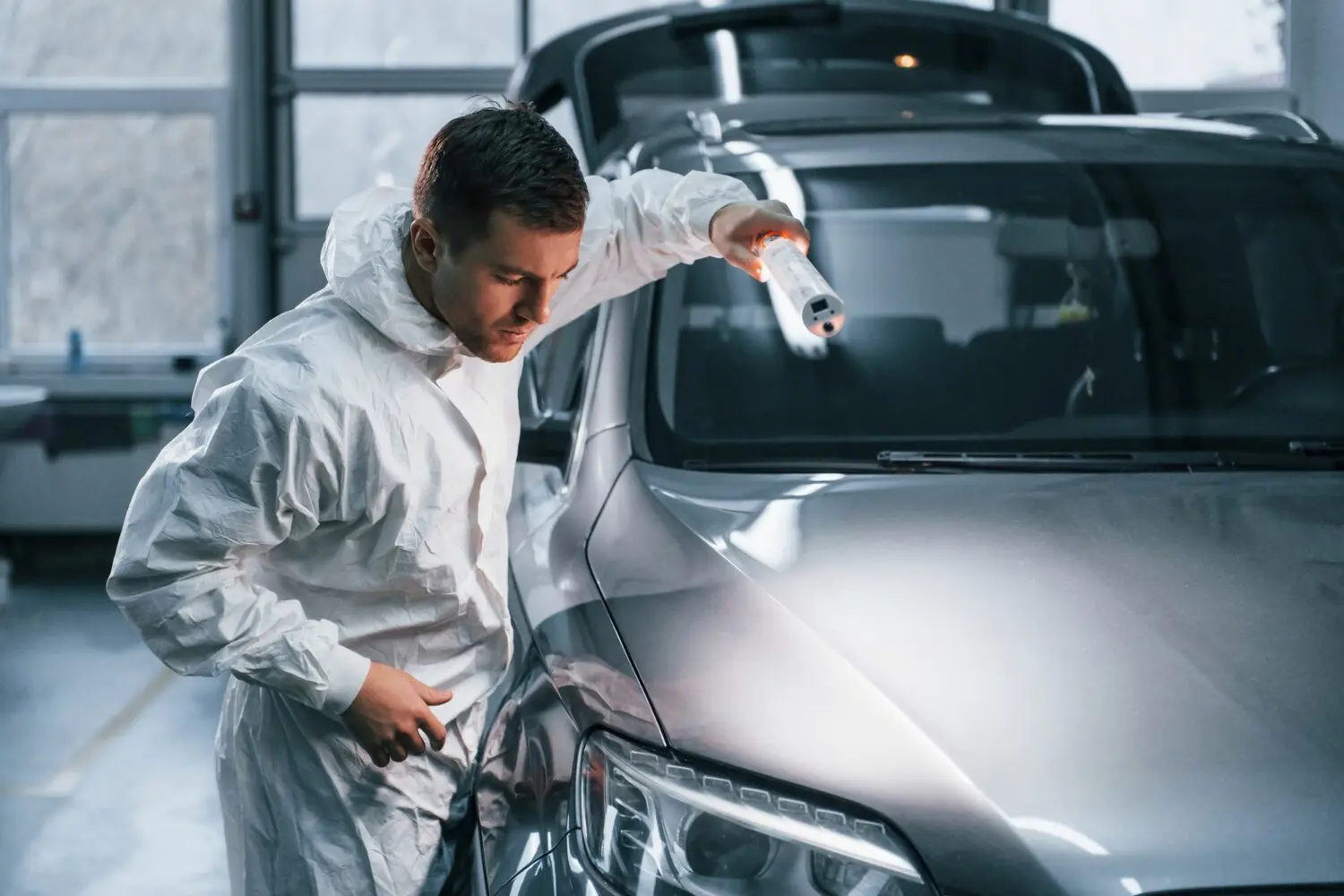 Technician inspecting a car at a vehicle recovery depot