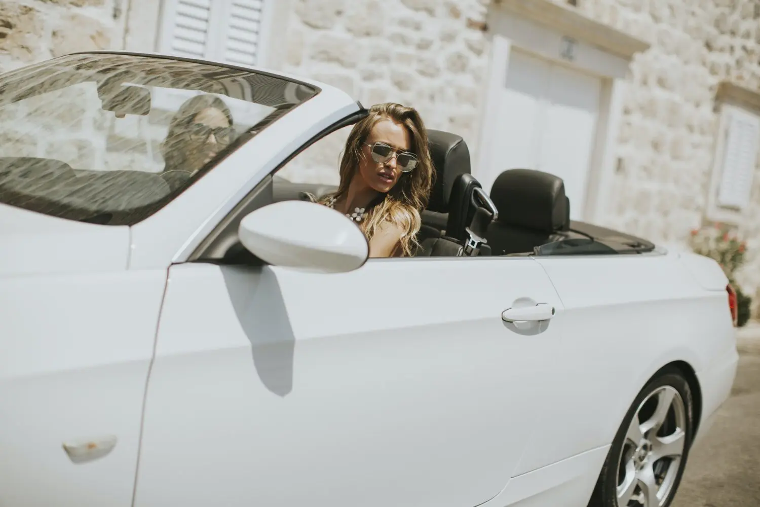 Classic white convertible on the road after being delivered by flatbed transport