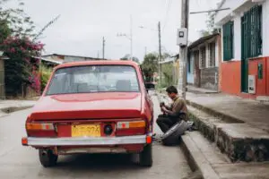 Tyre blowout at the roadside with a driver inspecting the deflated tyre