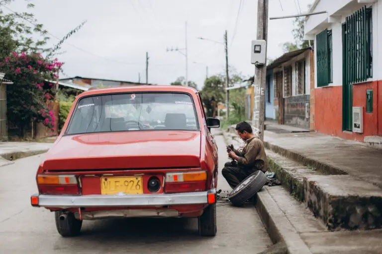 Tyre blowout at the roadside with a driver inspecting the deflated tyre