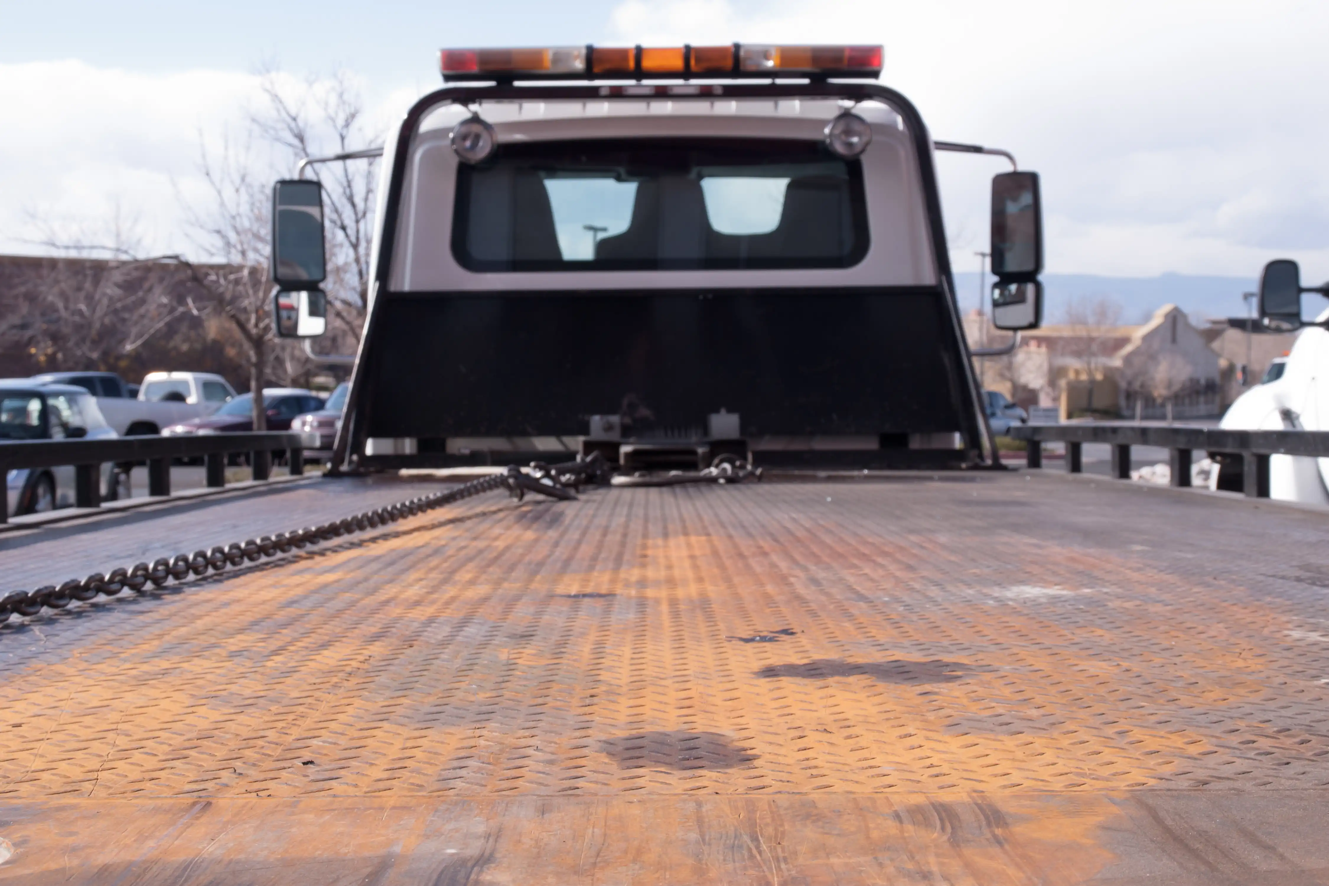 Vehicle securely strapped to Fast Track Recovery flatbed truck with metal chains
